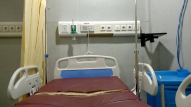 Boş bir oda, hastane yatağı ve bir bardak su.