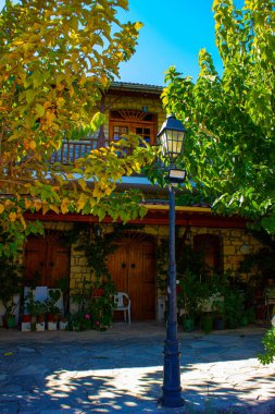 Kıbrıs 'taki Omodos köyündeki ağaçlar arasında eski taş binalar