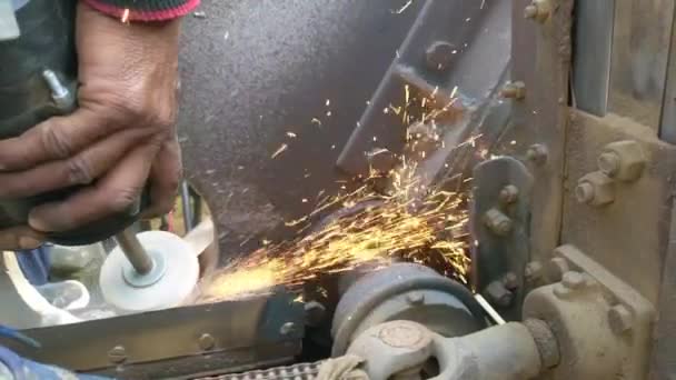 農業用脱穀機の金属産業労働者 乾燥した作物を切るために粉砕機で鉄の刃を研ぐ男 — ストック動画
