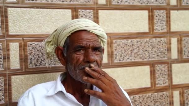 2022年12月20日 インド ラジャスタン州 喜びのインドの成熟した男喫煙と家の背景に隔離されたカメラを見て — ストック動画