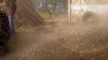 23 Aralık 2022 Jaipur, Rajasthan, Hindistan. Asyalılar tarım çiftliğinde eski moda bir harman makinesi kullanıyorlar.