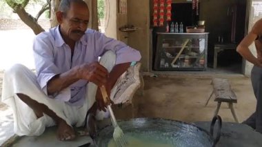 02 Ocak 2023 Jaipur, Rajasthan, Hindistan. Bir Halwai ya da Cook ünlü Hint tatlısını hazırlıyor. Bir aşçının misafirler için büyük bir Kadai 'de tatlı ya da tatlı bir süt hazırladığı yakın çekim.