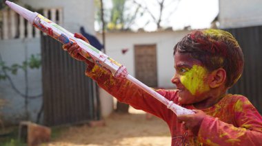 Hintli çocuklar Holi 'yi kutlarken su tabancasıyla boyuyorlar, Hindu bahar renk festivali..