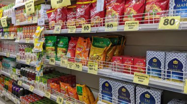 Süpermarkette sarı ve kırmızı renkli Taj Mahal çayı ve kırmızı lable çay paketleriyle raflar. Perakende sektörü. Raflarda satılık çeşitli çay paketleri.