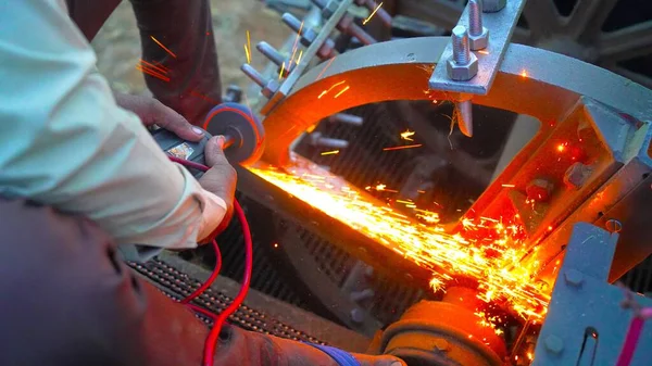 工人在农业中使用角磨床 喷出火花 工业工人用磨床切割金属 许多闪耀的火花 — 图库照片