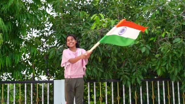 8月15日インドの幸せな独立記念日 10代の少女緑の木の背景にインドの旗を振って — ストック動画
