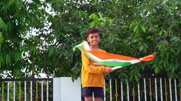 Indisk Pojke Håller Vinka Med Tricolor Med Grönska Bakgrunden — Stockvideo