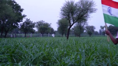Mutlu Bağımsızlık Günleri. Hindistan 'ın bağımsızlık günü kutlu olsun. Yeşil arka planda Kızılderili bayrağıyla koşan küçük kız.