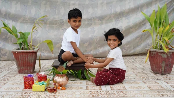 Kardeşinin Bileğine Rakhi Bağlayan Mutlu Bir Kız Stüdyo Arka Planında — Stok fotoğraf
