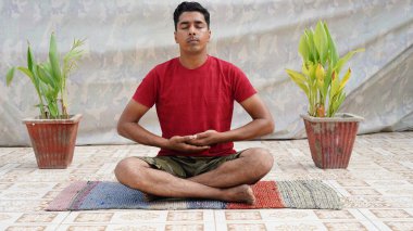 Kafkasyalı adam evde çatıda poz vererek yoga yapıyor.