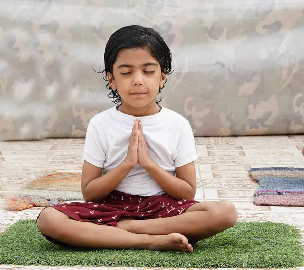 Küçük Hintli kız stüdyoda meditasyon yapıyor. Ruhum için dua ediyorum.