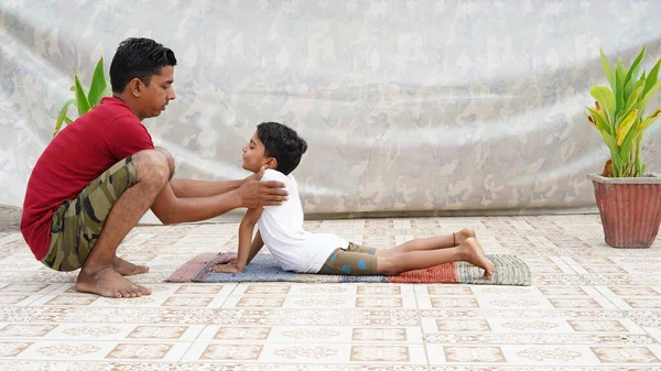 Asian Indian man fitness coach teach her student exercise in fitness center. Urdhva Mukha Shvanasana pose.