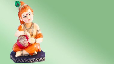 Yeşil arka planda Hindu tanrısı Krishna. Hindu tanrı Kanha çocukluk porselen heykelciği izole edin.