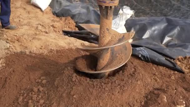 果実の苗を植えるための穴を掘る インドの田舎で掘るトラクターで取付けられた油圧ポストの穴のオーガーを作動させます — ストック動画