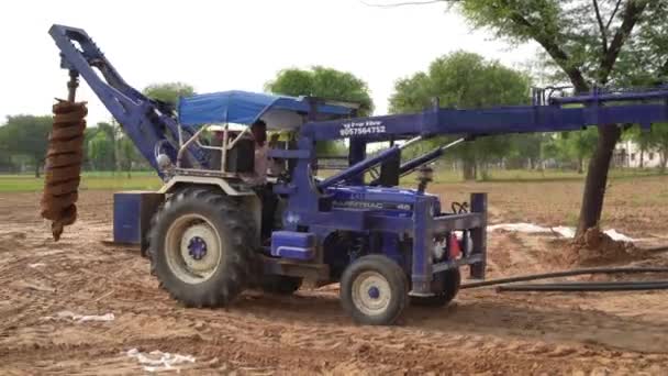 8月29日 2023 ジャイプール ラジャスタン インド 人々はインドの田舎フィールドで掘るトラクターに取付けられた油圧ポストホールオーガーを操作します 農業産業コンセプト — ストック動画