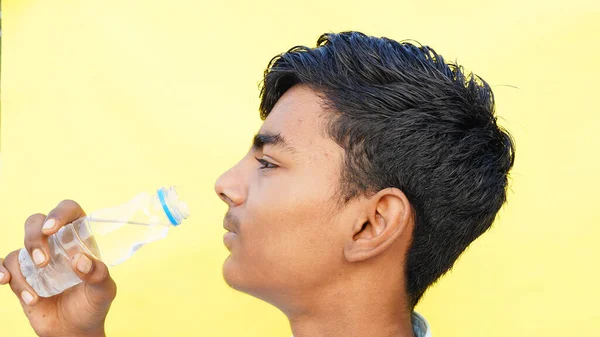 Asiatische Schulkinder Trinken Vor Dem Studiohintergrund Wasser Aus Einer Flasche — Stockfoto