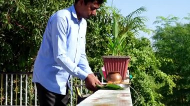 Hintli dindar adam yiyecek yerleştirdi ve karga kuşunu yemeğe davet etti. Hindu pitru paksha veya sharada festivali.