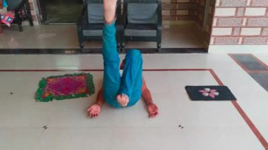 Genç Hintli adam evin içinde yerde yoga yapıyor. Sağlıklı yaşam ve yoga konsepti.
