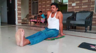 Hintli adam evdeki oturma odasında yoga meditasyonu yapıyor. Sabahları paspasın üzerinde meditasyon yapıyor.