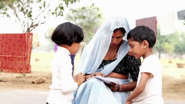 Красивая Индийская Женщина Традиционном Костюме Помогает Дочери Сыну Домашним Заданием — стоковое видео