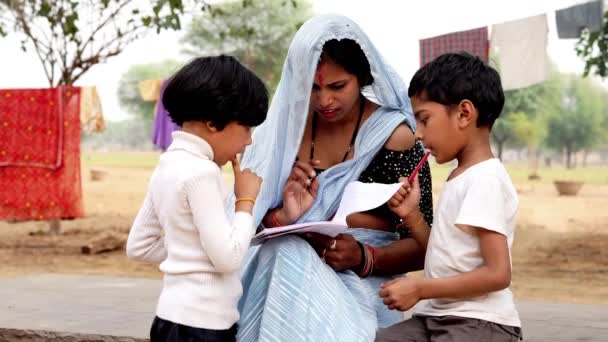印度乡村妇女在萨里教小女儿和小儿子读书 帮助完成小学作业 展示图片 讲述童话 — 图库视频影像