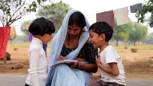 Красивая Индийская Женщина Традиционном Костюме Помогает Дочери Сыну Домашним Заданием — стоковое видео