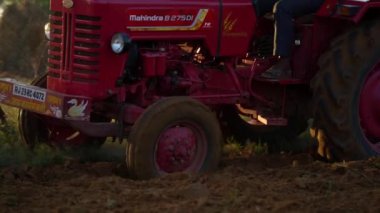 Sonbaharda kırmızı traktör sürüşü, traktörle tarla sürüşü tarla sürüşü tarla sürüşü, tarım çalışmaları. 25 Kasım 2023 Jaipur, Rajasthan, Hindistan.