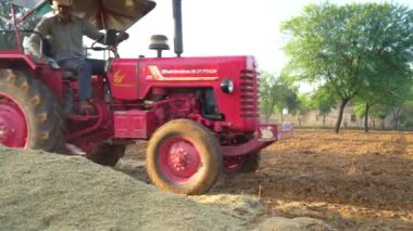 Çok satırlı bir disk harrow, hasat edilen bir buğday tarlası ve mavi bir gökyüzünün arka planına karşı bir tarım traktörüne bağlanıyor. 25 Kasım 2023 Jaipur, Rajasthan, Hindistan.