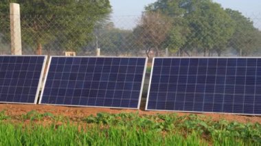 Hindistan 'ın kırsal kesimlerinde düzgün düzenlenmiş güneş panelleri. Sisli bir günde bir dizi güneş paneli. Bir güneş çiftliğinin resimleri