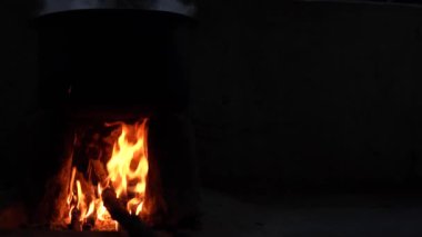Odundan ateş yak ve yemeği hazırlamak için büyük bir tencere koy. Odun yakmak için kullanılan bulanık görüntüler..