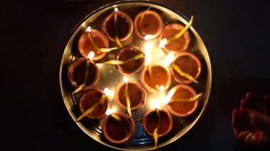 Ram mandir açılışı vesilesiyle toprak lambası veya Diyas yakan Hintli aile üyeleri.