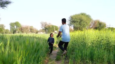 Küçük kız buğday tarlasında koşuyor. Mutlu aile bir rüya çocuk konsepti. Kız çocuk buğday tarlası parkında oyun oynuyor. Mutlu çocukluk özgürlüğü kavramı. Yazın koşan özgür kız çocuğu
