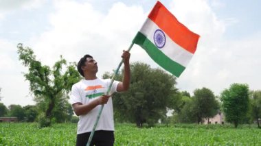 Hintli çocuklar Bağımsızlık Günü 'nü ya da Cumhuriyet Günü' nü kutluyor. Beyaz tişörtlü ve Kızılderili bayrağı taşıyan çocuklar. Asya kırsalının görüntüleri