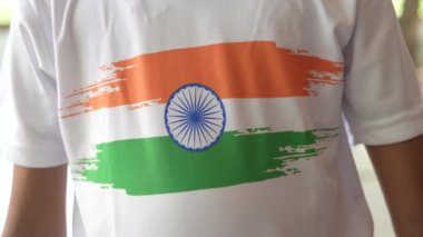 Ulusal bayrak logosu tasarımı giyen Hintli köylüler tişört basıp tutuyorlar, arka planda yeşillik olan Tricolor 'la el sallıyorlar, Bağımsızlık Günü' nü veya Cumhuriyet Günü 'nü kutluyorlar.