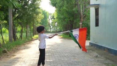 Ulusal bayrak logosu tasarımı giyen Hintli köylüler tişört basıp tutuyorlar, arka planda yeşillik olan Tricolor 'la el sallıyorlar, Bağımsızlık Günü' nü veya Cumhuriyet Günü 'nü kutluyorlar.
