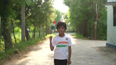 Ulusal bayrak logosu tasarımı giyen Hintli köylüler tişört basıp tutuyorlar, arka planda yeşillik olan Tricolor 'la el sallıyorlar, Bağımsızlık Günü' nü veya Cumhuriyet Günü 'nü kutluyorlar.