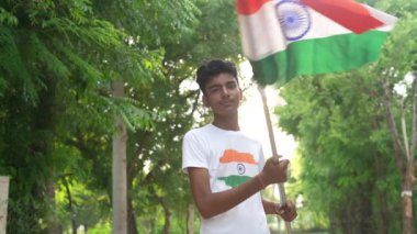 Hintli çocuklar Bağımsızlık Günü 'nü ya da Cumhuriyet Günü' nü kutluyor. Beyaz tişörtlü ve Kızılderili bayrağı taşıyan çocuklar. Asya kırsalının görüntüleri