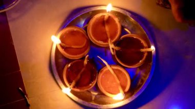 Diwali sırasında rangoli dizaynı ile mermer zeminde yakıldı. Kuğu şeklindeki bir saksıyı çevreleyen para ve çiçek süslemesi.