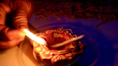 Yağ lambaları diwali kutlamaları sırasında renkli Rangoli 'leri aydınlatıyor, Rangoli' de diyas kullanılıyor. Diwali, Hinduların, Jainlerin, Sikhlerin ve bazı Budistlerin bir ışık festivali.