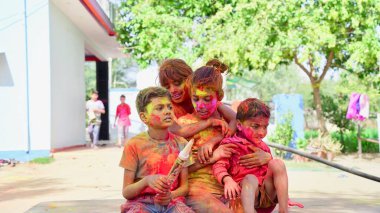 Çocuklar Holi rengine bürünmüş, Hintli çocuklar evde Gulal ile oynuyor Holi Festivali sırasında.