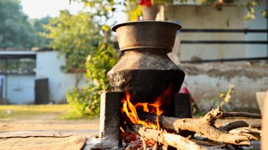 Rural Vintage Kitchen using firewood in-earthen chulhas for cooking food. clipart