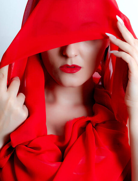 Portrait of a girl in a veil. A red veil covers the face.