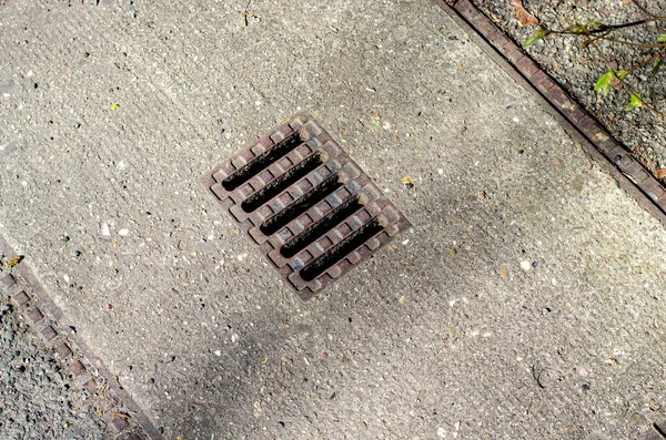 德国的一个街道上有金属格栅的下水道坑 — 图库照片