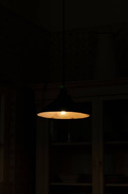 Abajur, karanlık bir odanın abajurunda parlıyor.