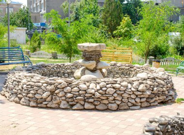 Berdyansk, Donetsk bölgesindeki halka açık parkta güneşli bir yaz günü Ukrayna 'da taştan bir çeşme.