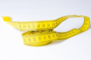 Beyaz arkaplanda kıvrılmış sarı mezura