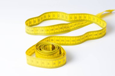 Beyaz arkaplanda kıvrılmış sarı mezura