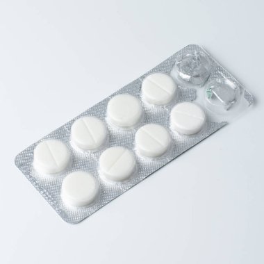 Tedavi ve sağlık hizmetleri için tıbbi tabletlerle dolu gümüş su toplayıcıları, beyazlar üzerinde izole edilmiş.