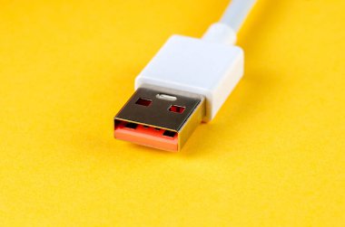 Parlak sarı arka planda beyaz USB-A kablosu, makro yakın plan