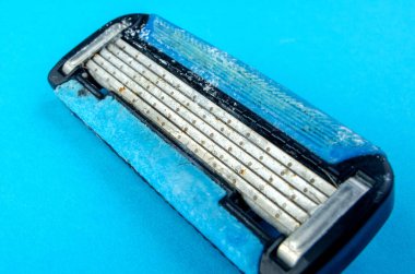 Hijyen ve tımar konsepti için parlak mavi arka planda kullanılmış tek kullanımlık jilet makrosu